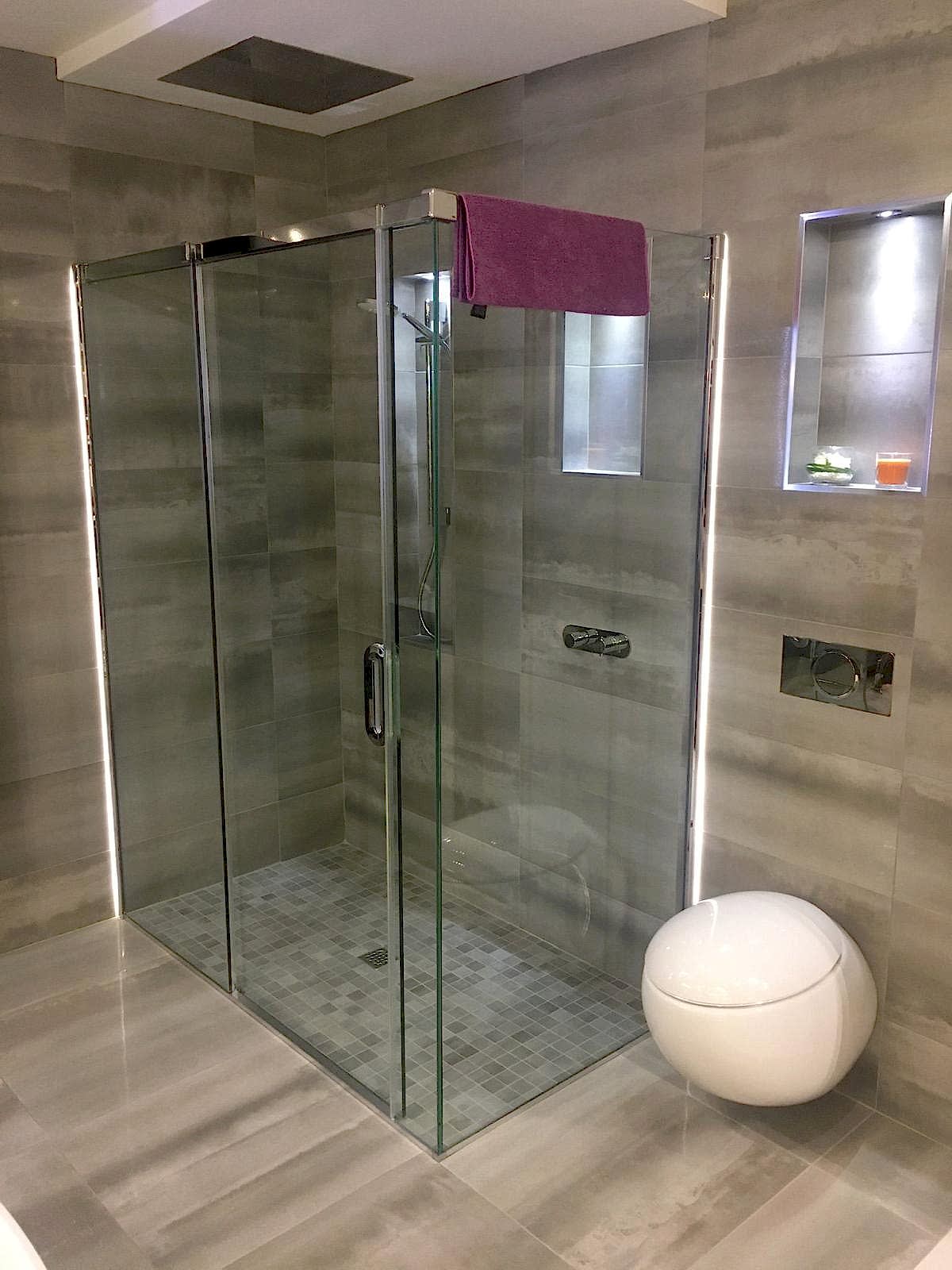 Close-up of a modern all-glass stand-in shower installed by AD Plumbing, Heating, and Electrical.